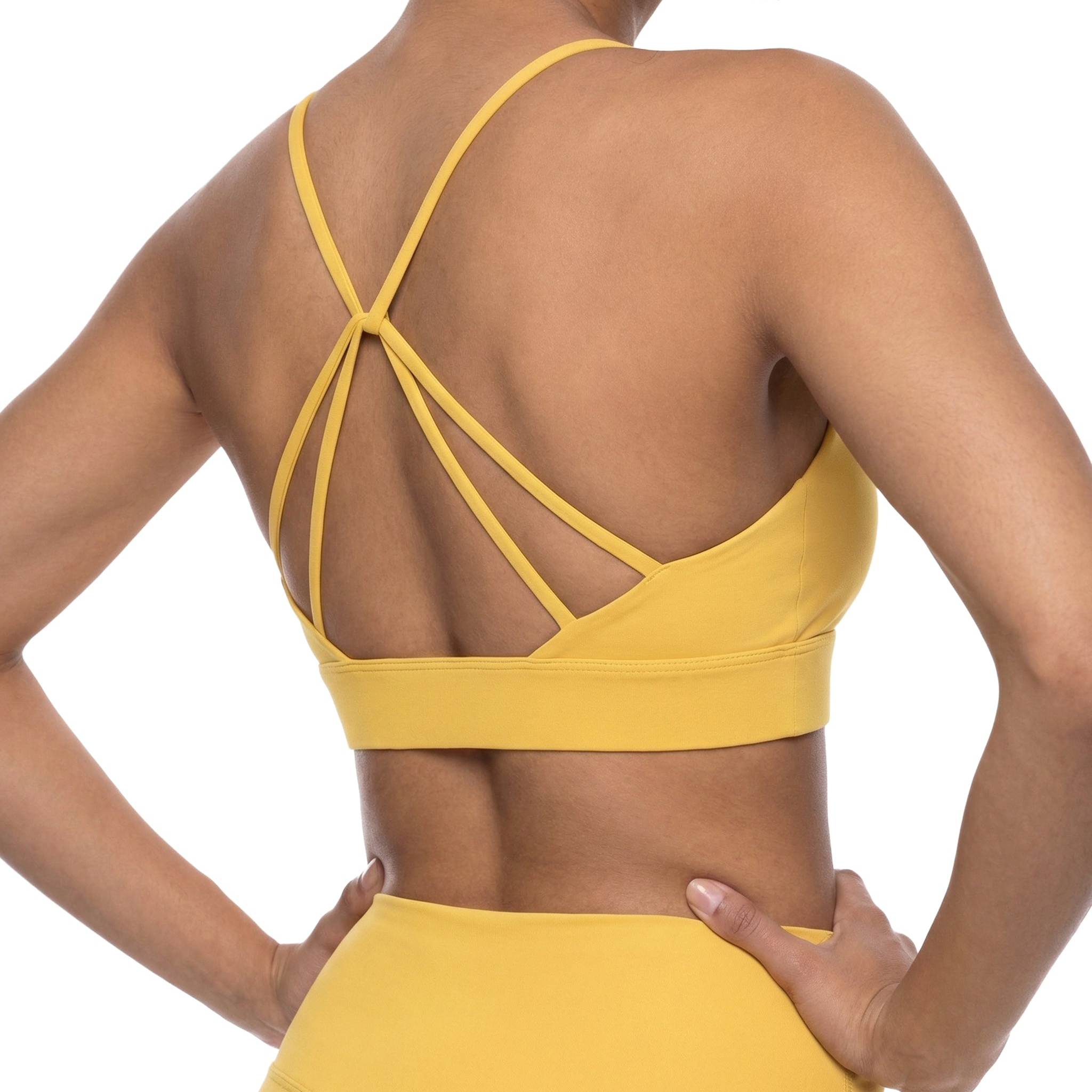 a woman wearing a yellow spaghetti sports bra and yellow leggings