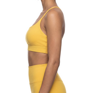a woman wearing a yellow spaghetti sports bra and yellow leggings